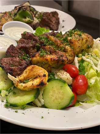 A plate of salad with beef and chicken.