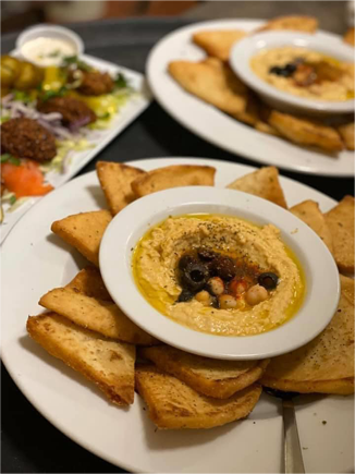 A plate of humus and baked pita bread.
